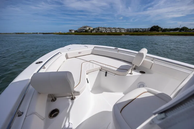 Slide: The Image of 2020 Sea Hunt Ultra 225 boat interior with seating, on calm water. - 9