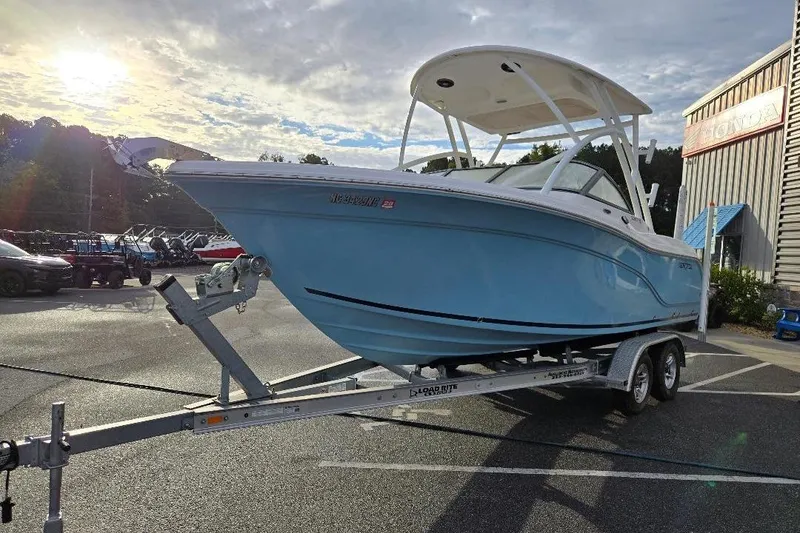 Slide: The Image of 2024 Sea Fox 228 Traveler boat on trailer in parking lot, under cloudy sky. - 3