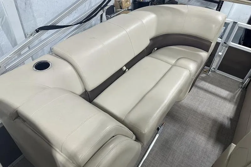 Slide: The Image of 2019 Sun Tracker Party Barge 22 RF DLX interior seating with beige upholstery and cup holder. - 6