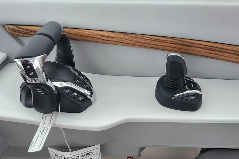 Slide: The Image of 2026 Regal LX9 boat interior with open storage compartment between gray seats. - 29