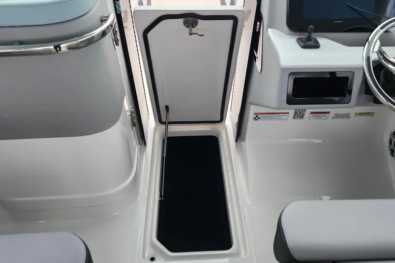 Slide: The Image of 2026 Regal LX9 boat storage compartment with black interior and red controls. - 32