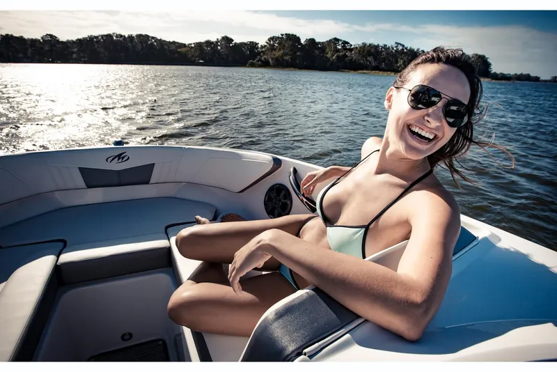 Slide: The Image of 2019 Monterey M-205 boat with Mercury engine, parked outdoors near other boats. - 2