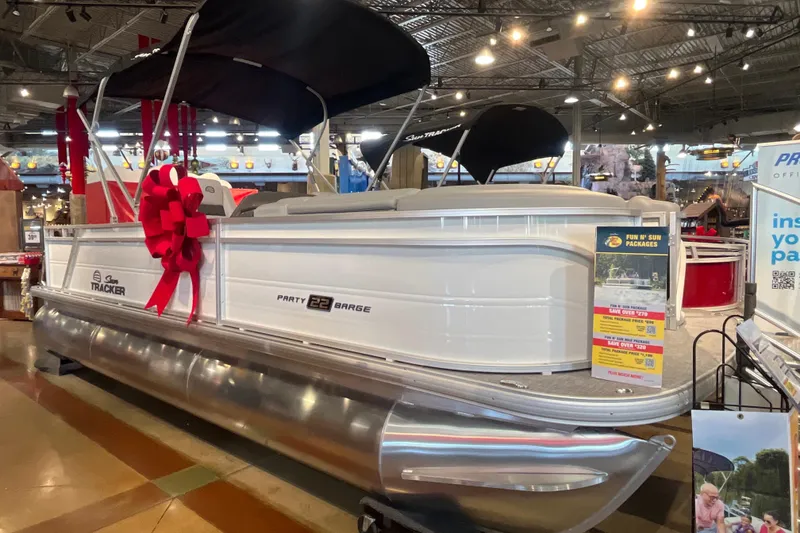 Slide: The Image of 2026 Sun Tracker Party Barge 22 RF XP3 pontoon boat with red bow in showroom display. - 10