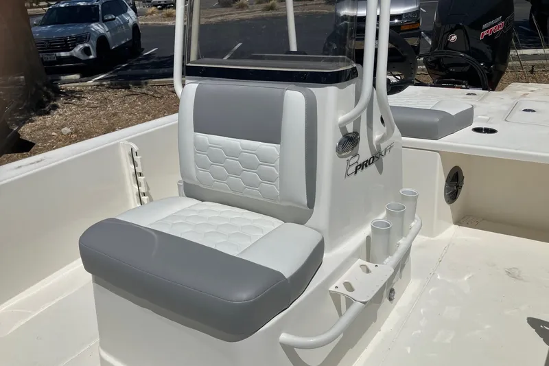 Slide: The Image of 2026 Mako 18 Pro Skiff boat interior with cushioned seating and rod holders. - 9