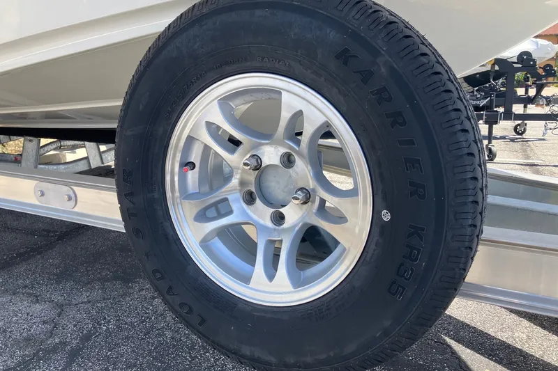Slide: The Image of Trailer wheel of 2026 Mako 18 Pro Skiff boat on pavement. - 6