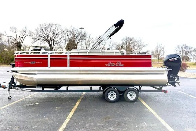 Slide: The Image of 2026 Sun Tracker Fishin' Barge 22 DLX pontoon boat on trailer in parking lot. - 88