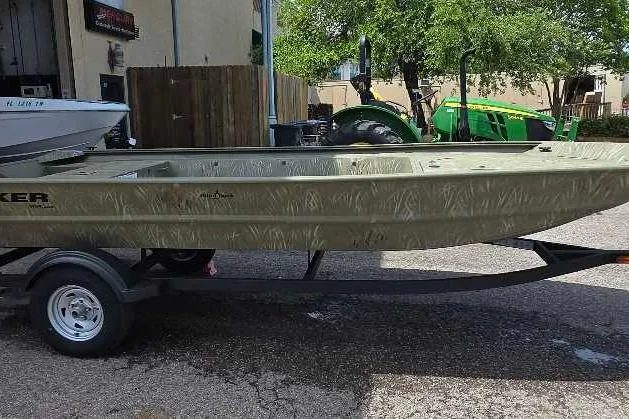 The Image of 2026 Tracker Grizzly 1754 Utility boat on trailer, parked outdoors. - 0