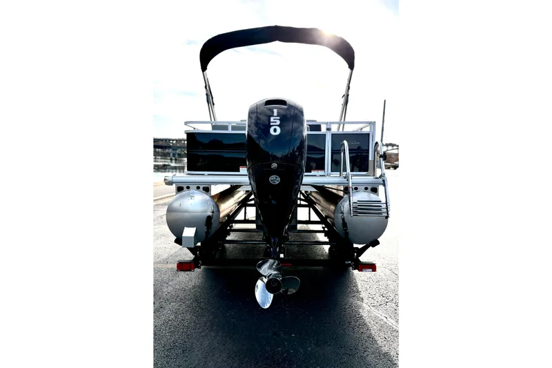 Slide: The Image of 2026 Sun Tracker Party Barge 22 RF DLX pontoon boat, rear view with motor and canopy. - 13