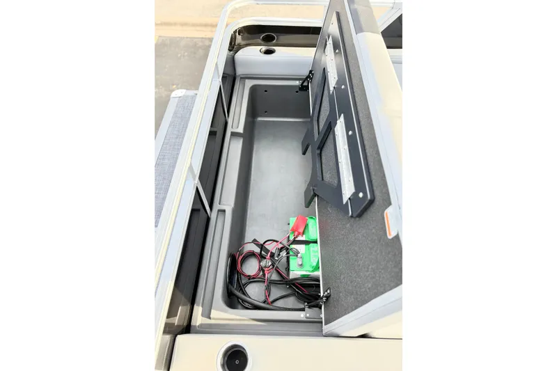 Slide: The Image of Open storage compartment in 2026 Sun Tracker Party Barge 22 RF DLX with battery and cables. - 20