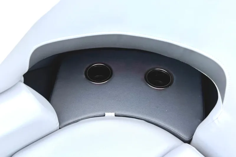 Slide: The Image of 2026 Sun Tracker Party Barge 22 RF DLX cup holders in cushioned seating area. - 26