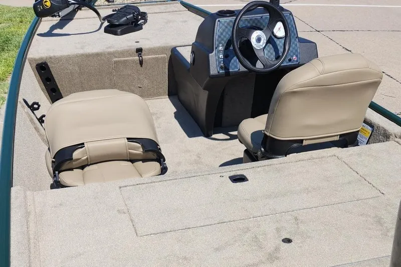 Slide: The Image of 2026 Tracker Bass Tracker Classic Limited boat interior with beige seats and steering console. - 12