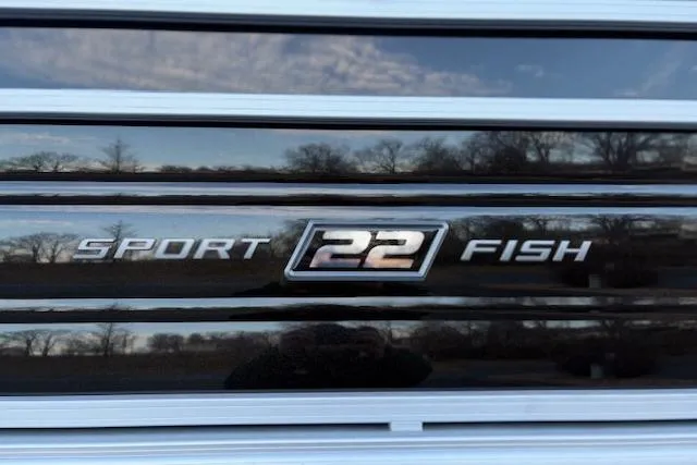 Slide: The Image of 2026 Sun Tracker SportFish 22 DLX logo on a sleek, reflective surface. - 102