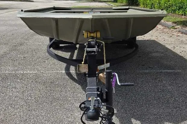 Slide: The Image of 2026 Tracker Grizzly 1754 Utility boat on trailer, parked on asphalt. - 2