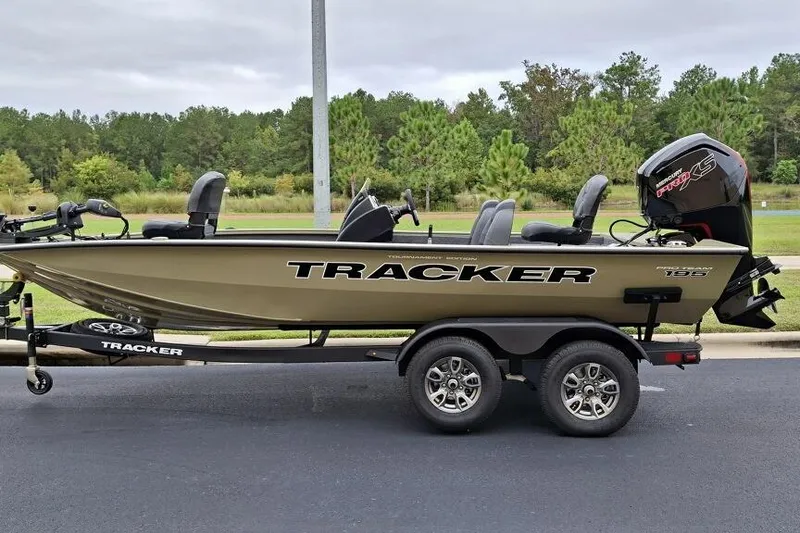 The Image of 2026 Tracker Pro Team 195 boat on trailer, parked on road with trees in background. - 0