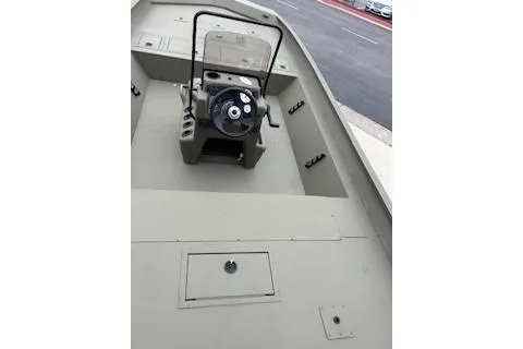 Slide: The Image of 2026 Tracker Grizzly 1860 CC boat interior with steering console, beige deck, and storage compartments. - 60