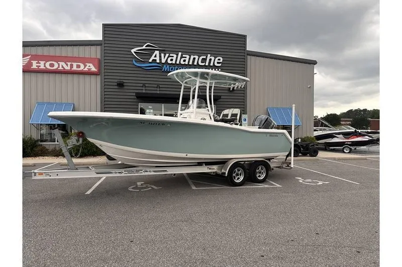 The Image of 2022 Tidewater 220 CC Adventure boat on trailer at dealership, overcast sky. - 1