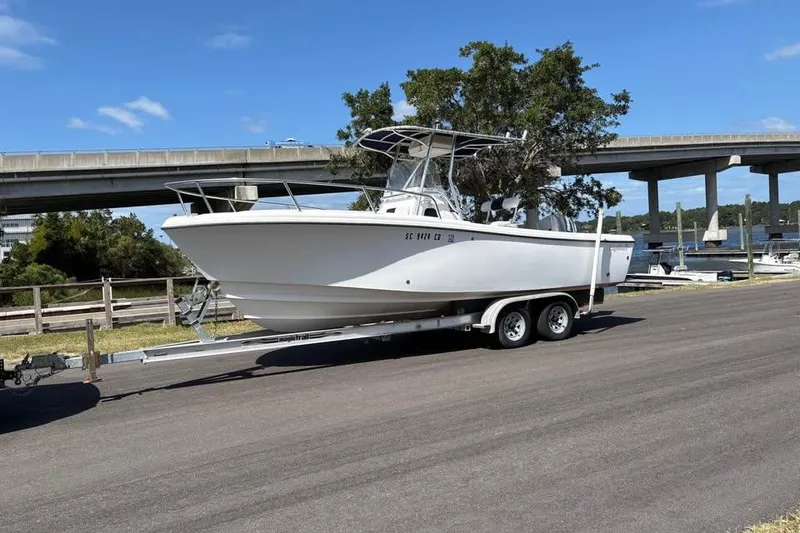 The Image of 2001 Edgewater 225CC boat on trailer near bridge and waterway. - 1