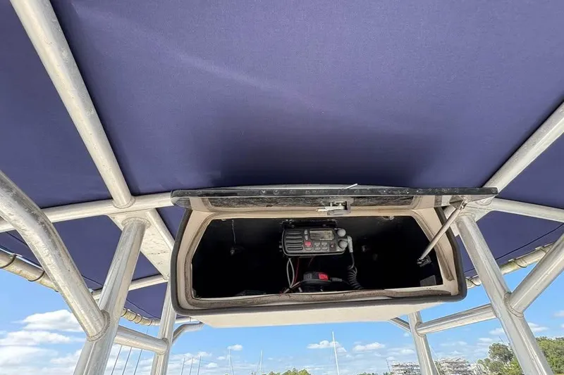 Slide: The Image of 2001 Edgewater 225CC boat with open electronics compartment under blue canopy. - 14