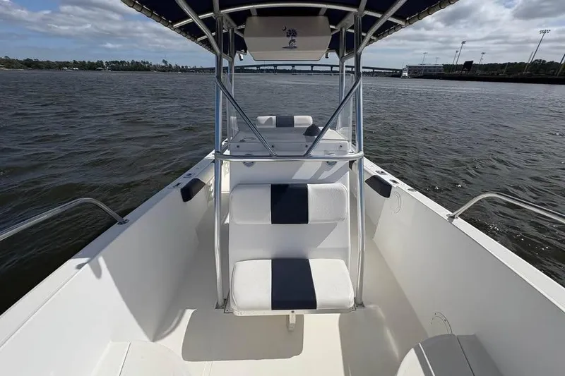 Slide: The Image of 2001 Edgewater 225CC boat interior with seating, on a calm waterway. - 18