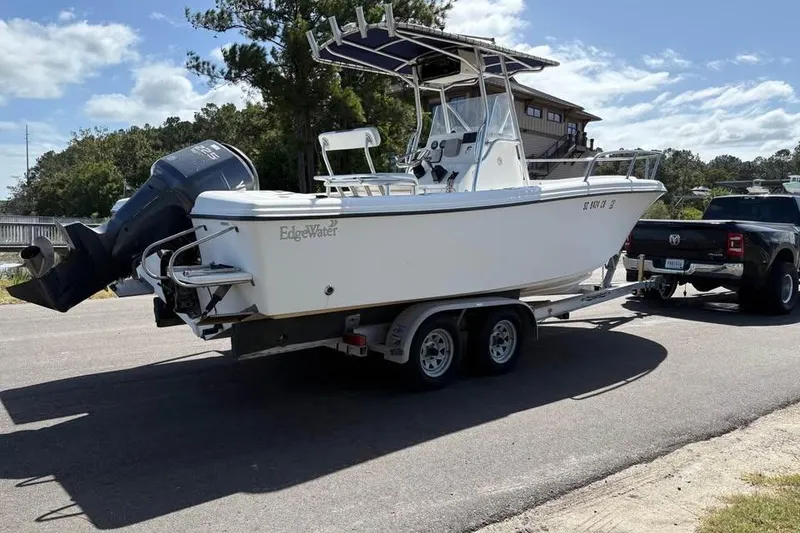 Slide: The Image of 2001 Edgewater 225CC boat on trailer, towed by a black truck, sunny day. - 4