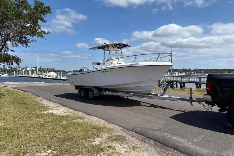 Slide: The Image of 2001 Edgewater 225CC boat on trailer near a scenic waterfront dock. - 5