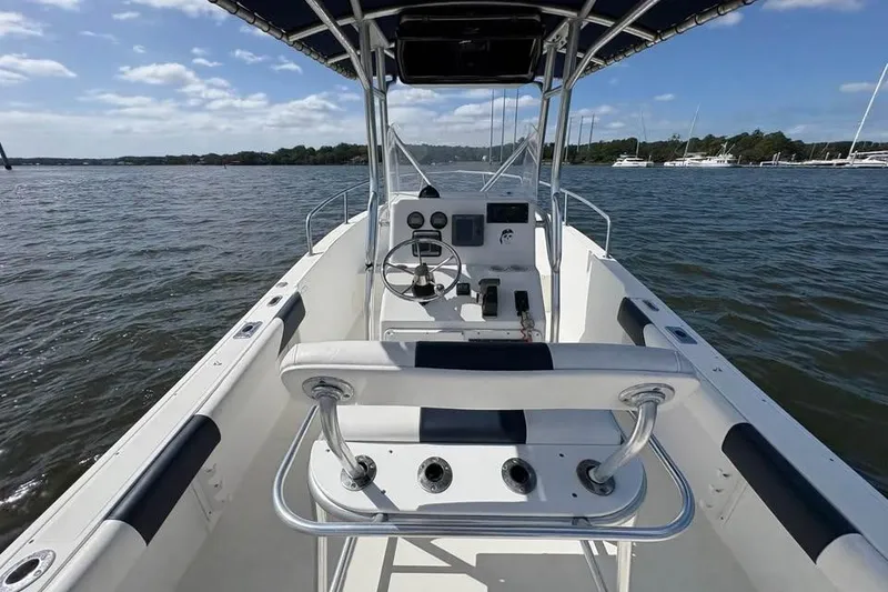 Slide: The Image of 2001 Edgewater 225CC boat on water, featuring center console and seating, under clear sky. - 6