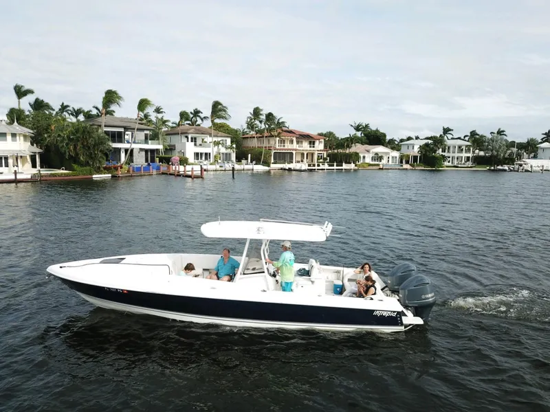Slide: The Image of 2005 Intrepid 323 Cuddy cruising near waterfront homes on a sunny day. - 0