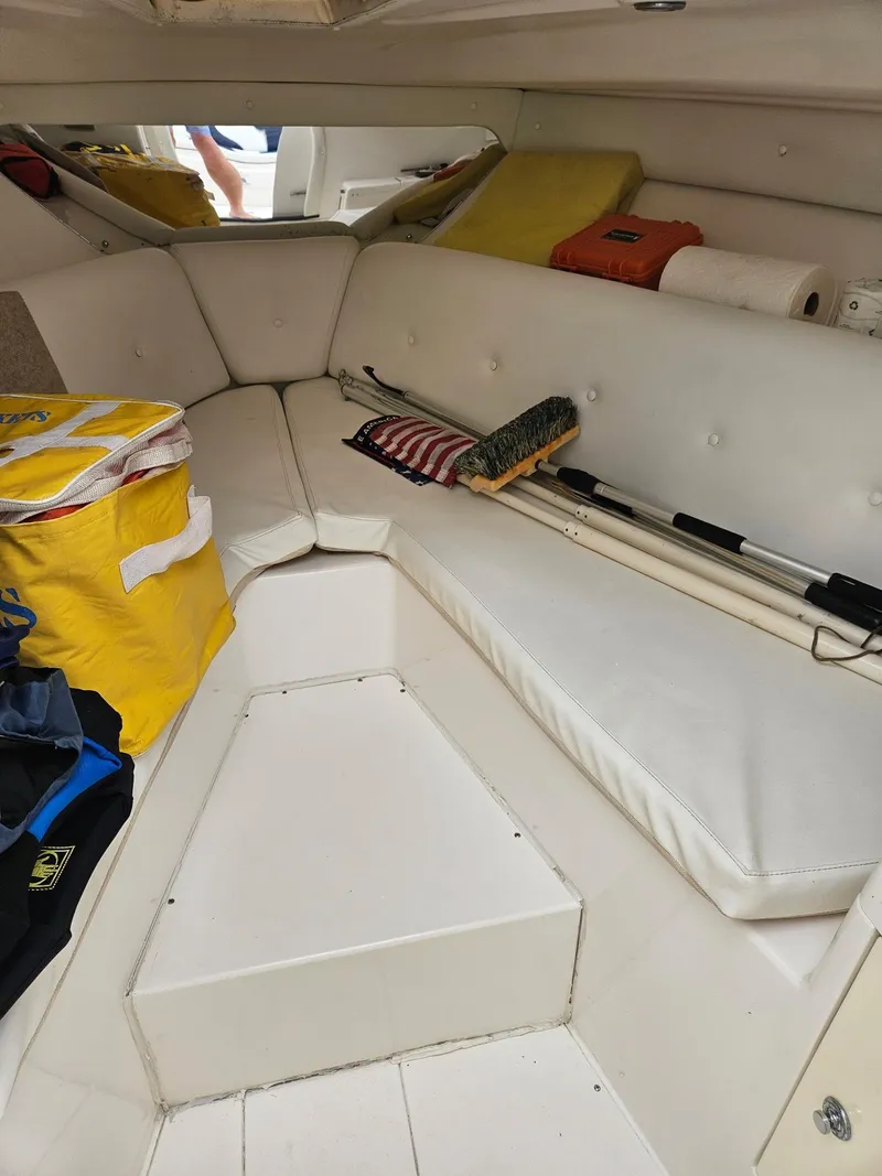 Slide: The Image of 2005 Intrepid 323 Cuddy cabin interior with white seating and storage items. - 10