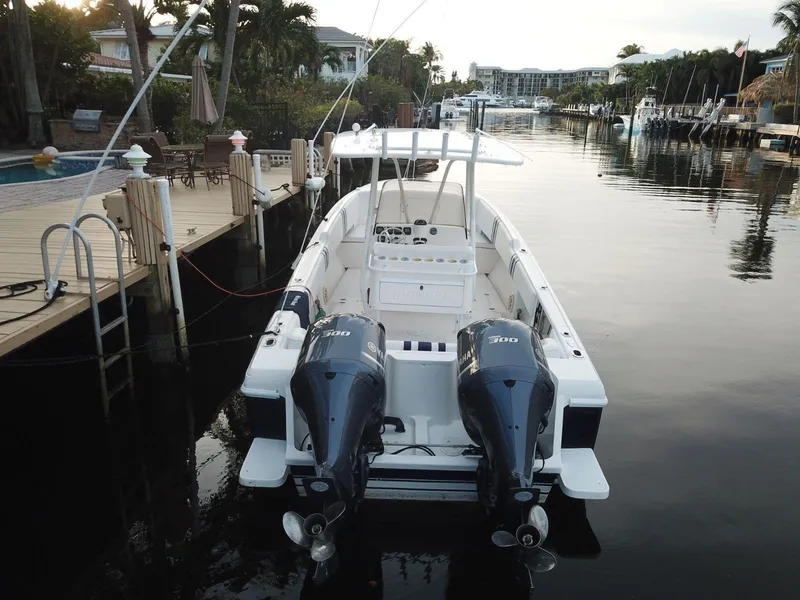 Slide: The Image of 2005 Intrepid 323 Cuddy boat docked with twin engines in a serene marina setting. - 12