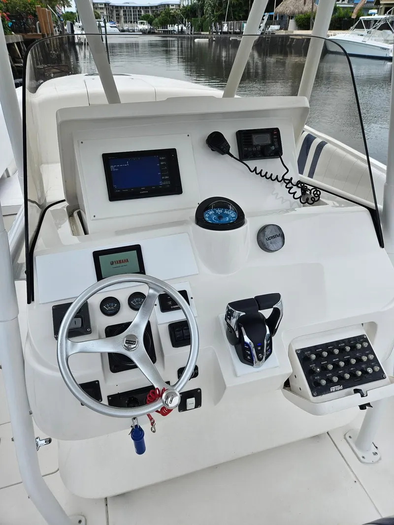 Slide: The Image of 2005 Intrepid 323 Cuddy boat dashboard with steering wheel, controls, and navigation equipment. - 6