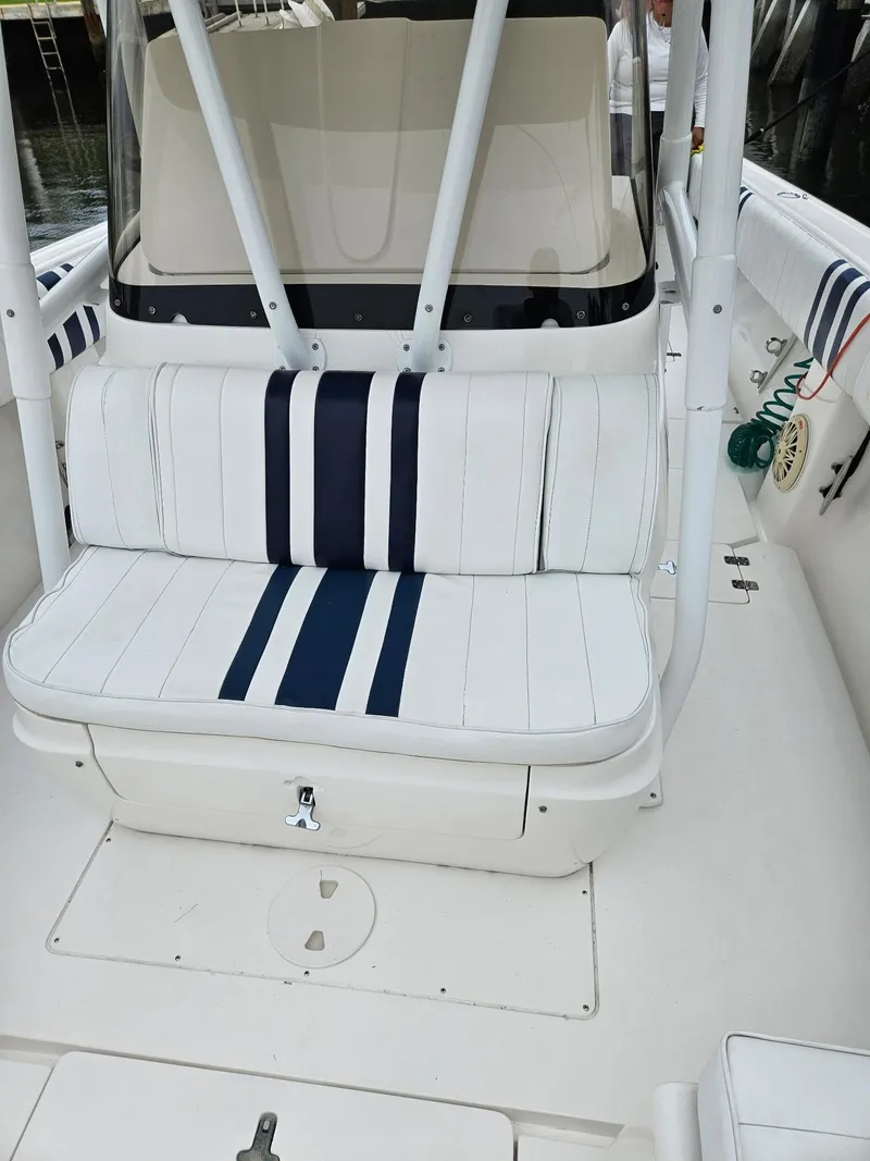 Slide: The Image of 2005 Intrepid 323 Cuddy boat with white and navy striped seating. - 7