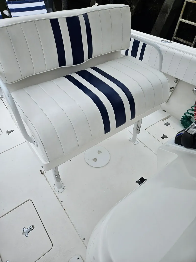 Slide: The Image of 2005 Intrepid 323 Cuddy boat interior with white and blue striped seating. - 8
