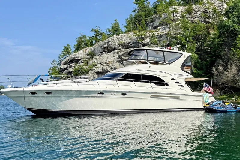 Slide: The Image of 2001 Sea Ray 560 Sedan Bridge yacht docked at marina under clear blue sky. - 0