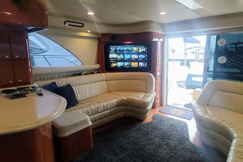 Slide: The Image of 2001 Sea Ray 560 Sedan Bridge yacht with American flag, docked at marina. - 13