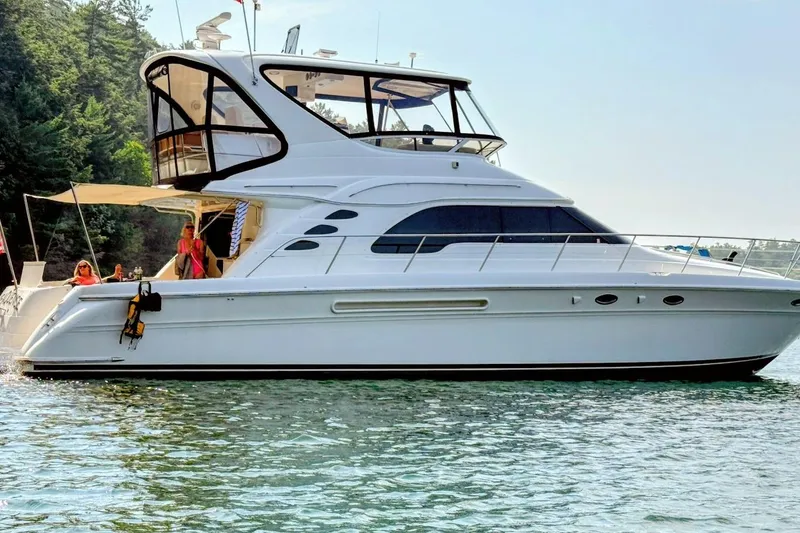Slide: The Image of 2001 Sea Ray 560 Sedan Bridge yacht docked in marina under clear blue sky. - 3