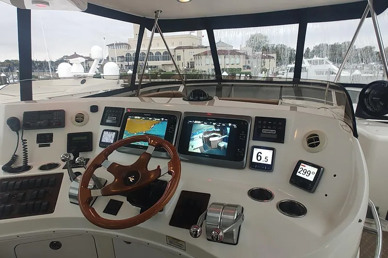 Slide: The Image of 2001 Sea Ray 560 Sedan Bridge interior with seating and table, overlooking marina. - 37