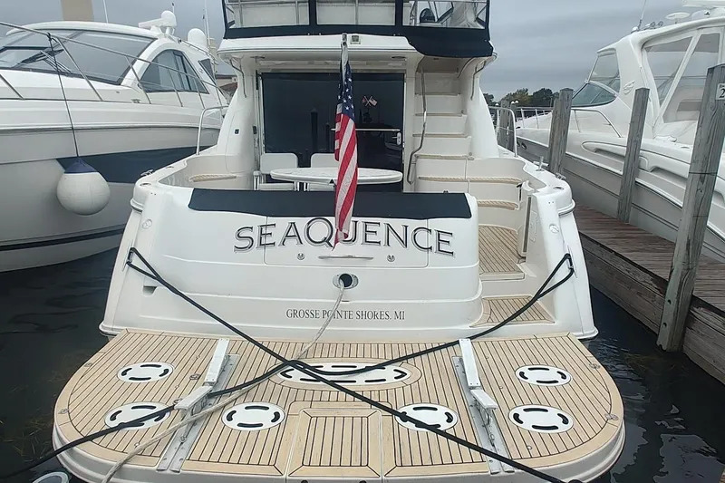 Slide: The Image of 2001 Sea Ray 560 Sedan Bridge yacht on calm water, surrounded by trees. - 7
