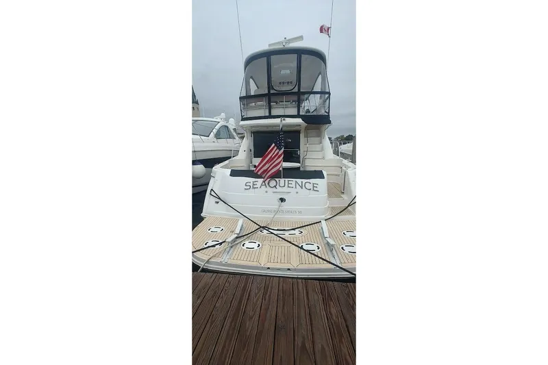 Slide: The Image of 2001 Sea Ray 560 Sedan Bridge yacht on a serene lake with lush greenery. - 9