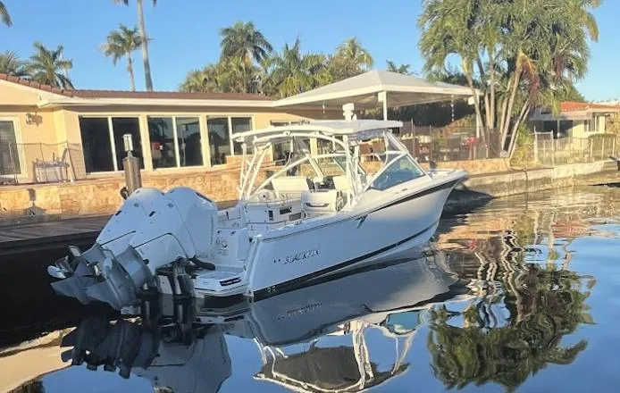 Slide: The Image of 2023 Blackfin 302 DC boat docked by a waterfront home. - 5
