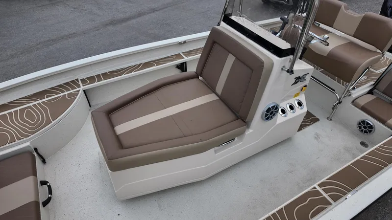 Slide: The Image of 2025 Xpress X23B Lounge boat interior with brown cushioned seating and modern design. - 16
