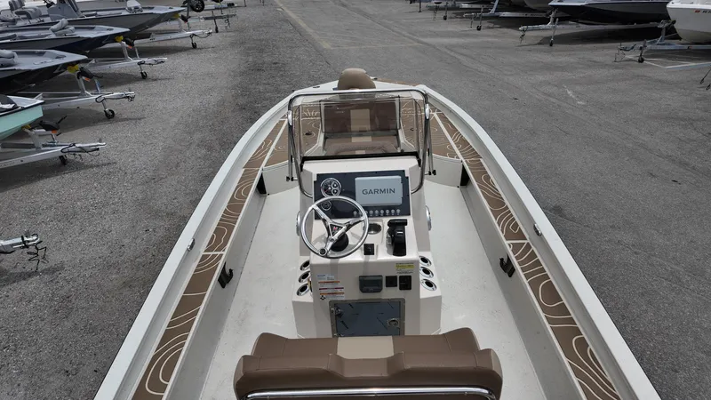 Slide: The Image of 2025 Xpress X23B Lounge boat with modern console and seating, parked in a marina. - 9