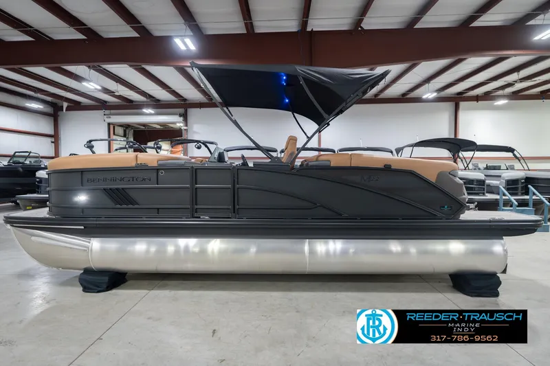 Slide: The Image of 2026 Bennington 22 MFB pontoon boat in showroom with canopy and sleek design. - 11