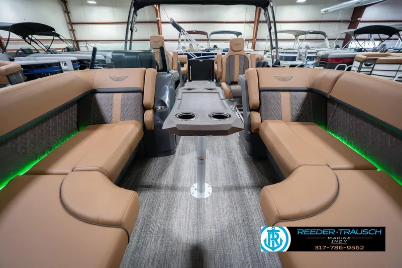 Slide: The Image of 2026 Bennington 22 MFB boat interior with tan seating and green LED lighting. - 16