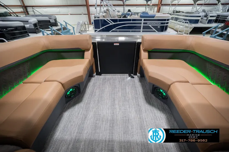 Slide: The Image of 2026 Bennington 22 MFB boat interior with tan seating and green LED lighting. - 18