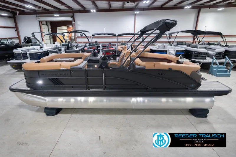 The Image of 2026 Bennington 22 MFB pontoon boat in showroom, featuring sleek design and tan seating. - 2