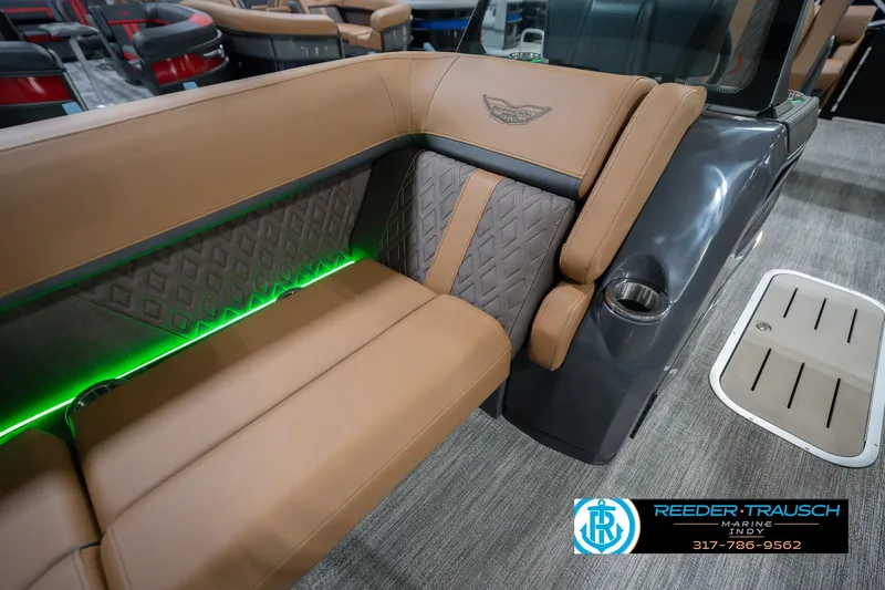 Slide: The Image of 2026 Bennington 22 MFB boat interior with tan seating and green LED lighting. - 25