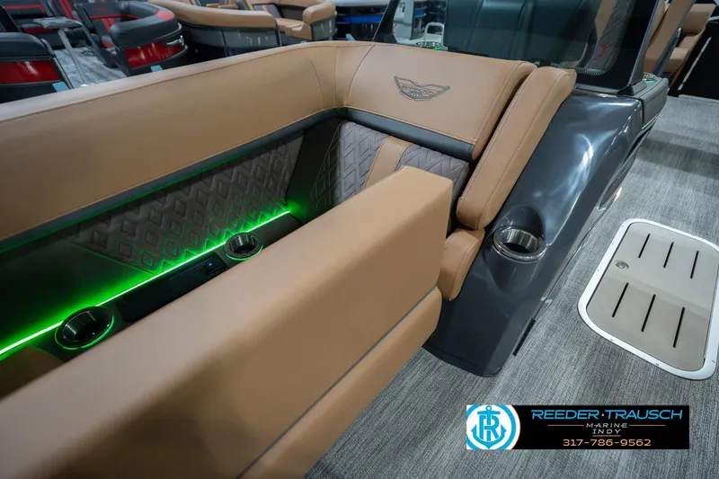 Slide: The Image of 2026 Bennington 22 MFB boat interior with tan seating and green LED lighting. - 27