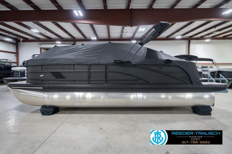 Slide: The Image of 2026 Bennington 22 MFB pontoon boat in indoor showroom, covered and secured. - 58