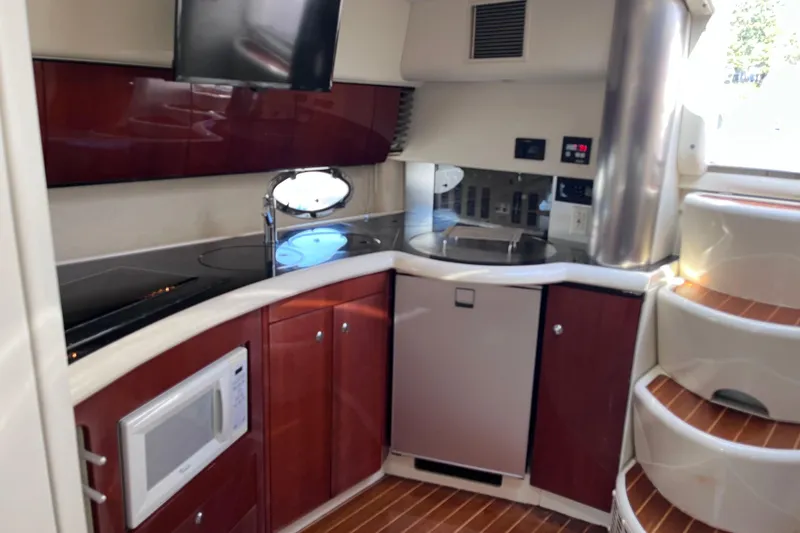 Slide: The Image of 2006 Fairline Targa 40 yacht interior kitchen with modern appliances and wooden cabinetry. - 19