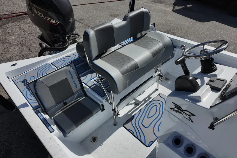 Slide: The Image of 2026 Xpress H22B Bay boat interior with seating, steering wheel, and Yamaha engine. - 12